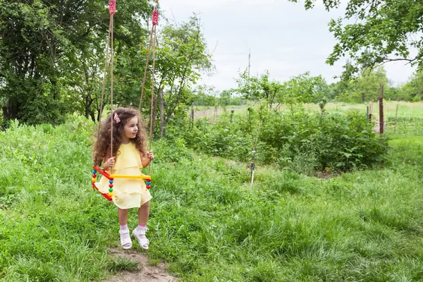 Curly baby girl on swing — Stock Photo, Image