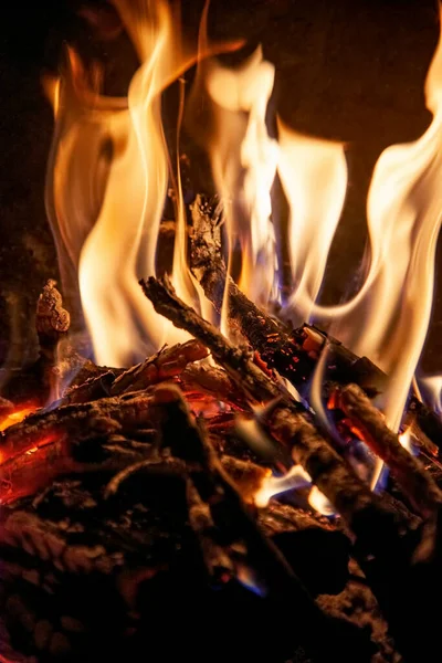 Burning wood in fireplace, tongue of flame and hot coals, Background of smoldering wood and flame in a fireplace close up