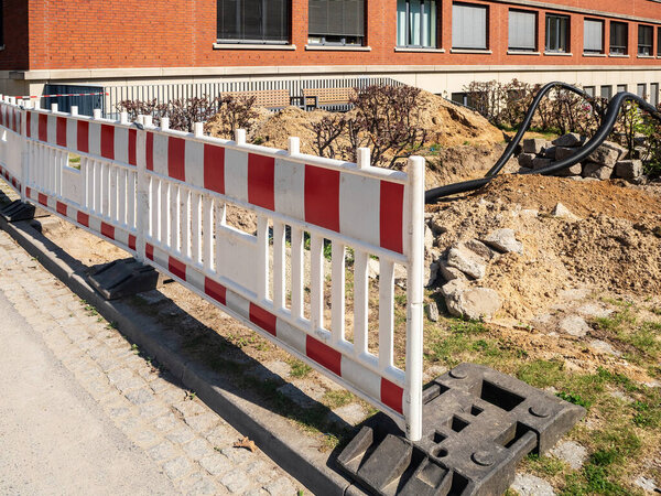 Safety fencing during water pipe repair. Replacing old water pipes with modern plastic piping. Laying of underground communications in the city of Berlin, Germany