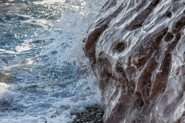 De golven overreden aan de wal — Stockfoto