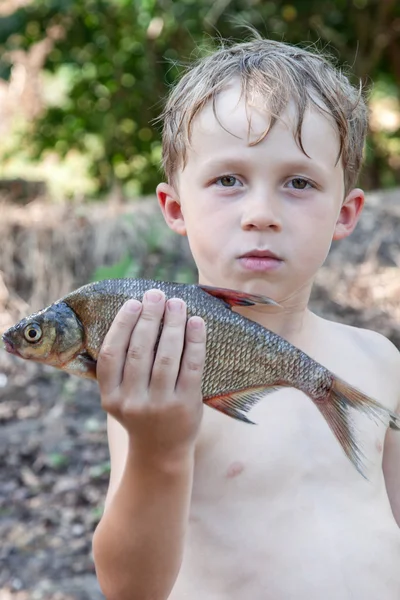 Garçon tenant un poisson mort — Photo