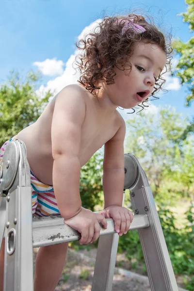 Baby girl standing on ladder — Stock Photo, Image