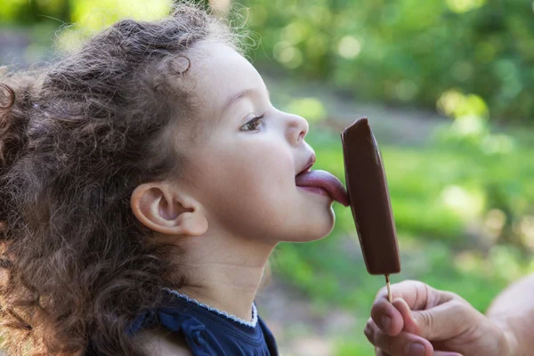 Bambino ragazza leccare gelato Fotografia Stock