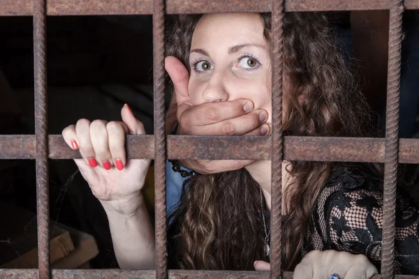 Woman hostage behind bars — Stock Photo, Image