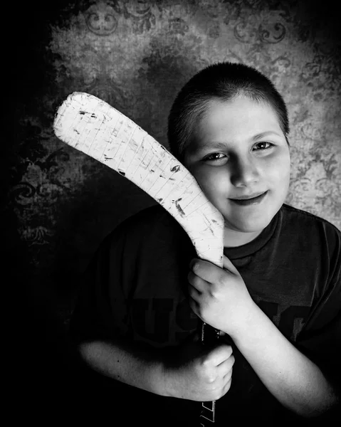 Chłopiec z kija hokejowego kocha na lodzie — Zdjęcie stockowe