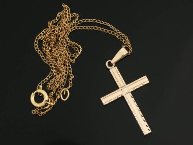 Altın zincirli kolyede parlak bir altın haç kolyesi. Dini mücevherler. Hıristiyanlık.