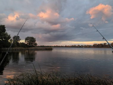 Güzel bir yerde balık tutmak. Olta ve su. Gün batımında balıkçı. Güzel manzara ve balıkçılık