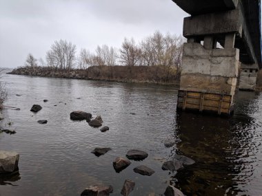 Nehirli sonbahar manzarası. Kışın boş bir sahil. Su ve taşlar