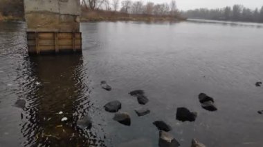 Nehirli sonbahar manzarası. Kışın boş bir sahil. Su ve taşlar