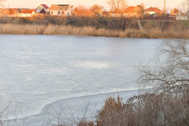 Nehirdeki buz. Nehirli kış manzarası. Kıyıda su ve sazlıklar. Kışın sudaki yansıma