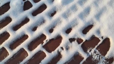 Karda tuğlalar. Duvar ve kar. kahverengi tuğlalar