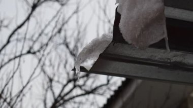 Çatıda buz saçakları var. Kar ve buz erir. Buz saçakları damlıyor. bahar damlaları