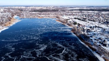 Yukarıdan donmuş göl. Donmuş bir gölün üstünde. Güzel bir doku. Donmuş göl ve kuru bitki örtüsü. Hava görüntüsü. Buz kıran donmuş gölün üzerinden uçmak. Kış mevsiminde hava fotoğrafçılığı.