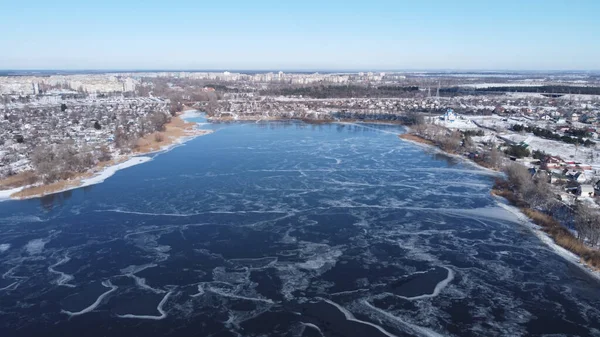 frozen lake from above. Above a frozen lake. Beautiful texture. Frozen lake and dry vegetation. Aerial view. Flight over frozen lake breaking ice. Aerial photography during winter season.