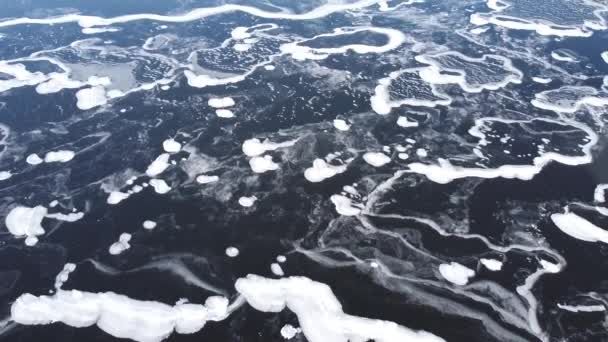 上から凍った湖 凍った湖の上だ 美しいテクスチャ 凍った湖と乾燥した植生 空中展望 凍った湖の氷の上を飛ぶ 冬の空中写真 — ストック動画