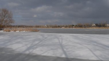Kar nehri manzarası. Kırsal alan. Buz nehirde yüzer. 4K görüntüler. Donmuş bir nehirde kışın buz kırılır. Buhar kışın donmuş nehrin üzerinden akıyor.