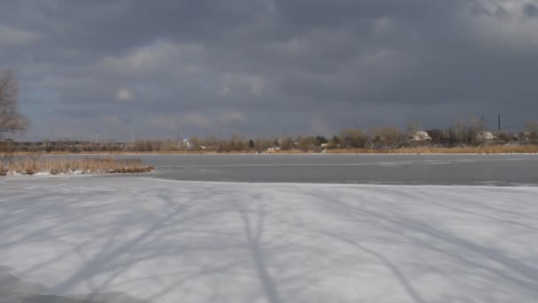 冬の雪の川の風景 田舎の風景 川に氷が浮かんでいる 4K映像 凍った川で冬には氷が砕ける 冬には凍った川を泳いで逃げる — ストック動画
