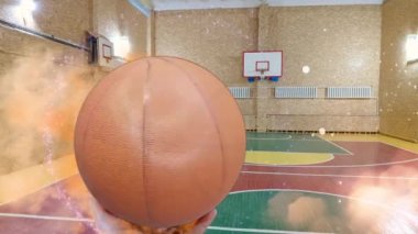 Bir basketbol topu ringe uçuyor. Basketbol topu. Basketbol potası. Basketbol salonunda. Modern basketbol arenasında parlayan ışıklar ve ahşap kortta top hareketi. 