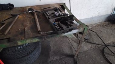 Atölyedeki tekerleklerin montajı ya da sökülmesi. Aracın onarımı ve bakımı hizmetinizde. İşçiler, İngiliz anahtarı tekerlek kamyonunu insan kolu 4K ile tamir ediyor. otomatik servis