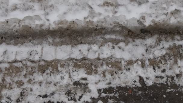 얼어붙은 발자국들 얼음에 자국을 속에서 도시의 거리를 뒤덮은 전도지와 발자국 — 비디오