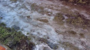 Kar ilkbaharda erir. Tarlada eriyen kar. Bahar geldi. Eriyen karı kapat. Dolly içeride. Bahar güneşinin altında kar yağışı erir. Erimiş su damlaları geçen seneki çimlerin üzerine akıyor..