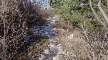 Kar ilkbaharda erir. Tarlada eriyen kar. Bahar geldi. Eriyen karı kapat. Dolly içeride. Bahar güneşinin altında kar yağışı erir. Erimiş su damlaları geçen seneki çimlerin üzerine akıyor..