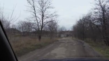 Kötü bir yolda araba kullanmak. Kötü hava, trafik ve bakımsızlığın yol açtığı asfalttaki çukurlar. Kötü alfalt. Yoldaki derin çukurlar. tehlikeli hareket