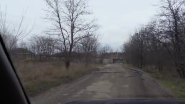 Kötü bir yolda araba kullanmak. Kötü hava, trafik ve bakımsızlığın yol açtığı asfalttaki çukurlar. Kötü alfalt. Yoldaki derin çukurlar. tehlikeli hareket