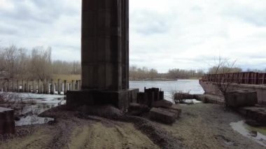 Büyük köprünün altında. Güçlü demir köprü yapısı, aşağıdan görünüyor. Köprünün altından bir nehir akıyor. Bakış açısı. Şehir mimarisi. Şafak vakti köprüde. Köprülerin inşası.