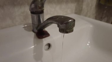 Musluktan su akıyor. Krom musluktan su akıyor. Banyo tesisatı. Su kaynaklarının kullanılması. Su tasarrufu kavramı, kullanım azalması. Su kaynağı problemleri. Spreyle akan su..