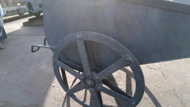 Sanayi tipi bir tramvay. Eski endüstriyel ekipmanlar. İki tekerlekli, paslı, eski model metal tramvayı izole ettim. Yakın çekim. Eski kullanılmayan ve terkedilmiş altın madeni tramvayı. 