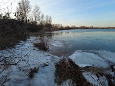 Nehirde güzel bir kış akşamı. Kışın İzlanda 'da nehrin havadan çekilmiş görüntüsü, gün batımı ve sis. Nehirli kış manzarası. Buz ilkbaharda erir. Suyun üzerinde erime.