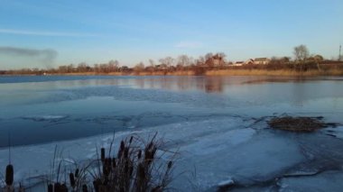 Nehirde güzel bir kış akşamı. Kışın İzlanda 'da nehrin havadan çekilmiş görüntüsü, gün batımı ve sis. Nehirli kış manzarası. Buz ilkbaharda erir. Suyun üzerinde erime.