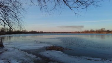 Nehirde güzel bir kış akşamı. Kışın İzlanda 'da nehrin havadan çekilmiş görüntüsü, gün batımı ve sis. Nehirli kış manzarası. Buz ilkbaharda erir. Suyun üzerinde erime.