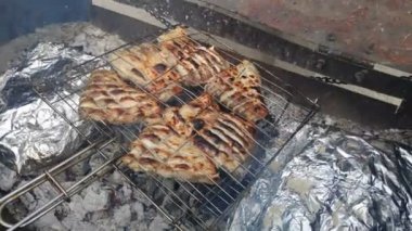 Izgara balık. Kızarmış somon balığı ve ızgarada çeşitli sebzeler. Yemeği ateşte pişirmek. Izgara ateşte tuzlu ızgara balık yemlerine yakın durun.