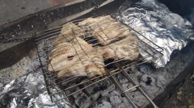 Izgara balık. Kızarmış somon balığı ve ızgarada çeşitli sebzeler. Yemeği ateşte pişirmek. Izgara ateşte tuzlu ızgara balık yemlerine yakın durun.