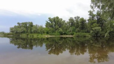 Kum ve suyla kaplı bir manzara. Ağaçların yansıması. Yağmurdan önce bulutlu hava.