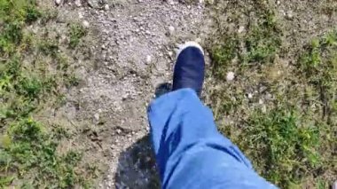 Erkek bacakları yol boyunca yürüyor. Erkek ayakkabısı. mavi kot