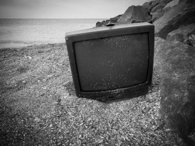 Eski bozuk televizyon. Televizyonu yere bırak. Deniz kenarındaki televizyon.