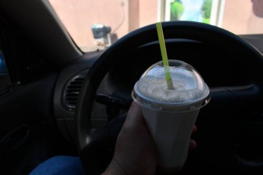 Milkshake arabada. Kamışlı bir bardak milkshake.