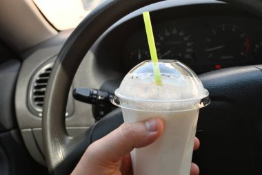 Milkshake arabada. Kamışlı bir bardak milkshake.