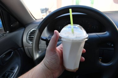 Milkshake arabada. Kamışlı bir bardak milkshake.