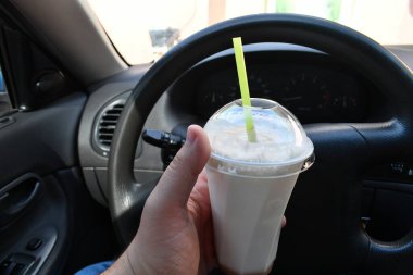 Milkshake arabada. Kamışlı bir bardak milkshake.