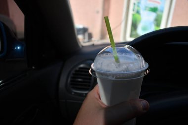Milkshake arabada. Kamışlı bir bardak milkshake.