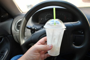 Milkshake arabada. Kamışlı bir bardak milkshake.