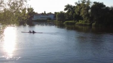 Kanoda yüzmek. Gün batımında kanolar. Tekneler ve ışıltılar suda.