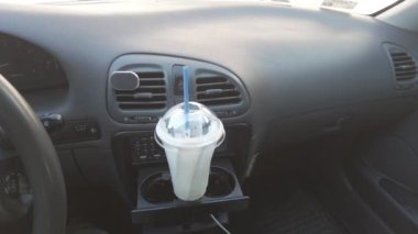 Milkshake arabada. Bir bardak milkshake ve pipetle. Süt içeceği arabada.