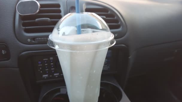 奶昔在车上 一个装有奶昔和稻草的杯子 车里的牛奶饮料 — 图库视频影像