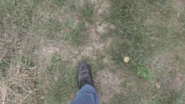 Erkek bacakları. Kot pantolon. Siyah ayakkabılar. Patika boyunca yürü. Adam serbest kalacak. Birinci şahıs görüşü. 4k video