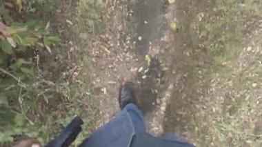Erkek bacakları. Kot pantolon. Siyah ayakkabılar. Patika boyunca yürü. Adam serbest kalacak. Birinci şahıs görüşü. 4k video